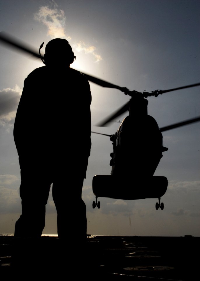 US Navy 091029-N-5538K-134 Aviation Support Equipment Technician 2nd Class Dean T. McRae guides a Marine Corps CH-46E Sea Knight helicopter onto the amphibious transport dock ship USS Denver (LPD 9)