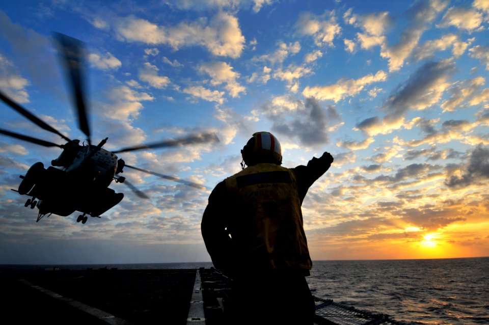 US Navy 091029-N-0807W-634 Boatswain's Mate 2nd Class Carigo A. Rula, directs a Marine Corps CH-53E Sea Stallion helicopter from the flight deck of USS Harpers Ferry (LSD 49)