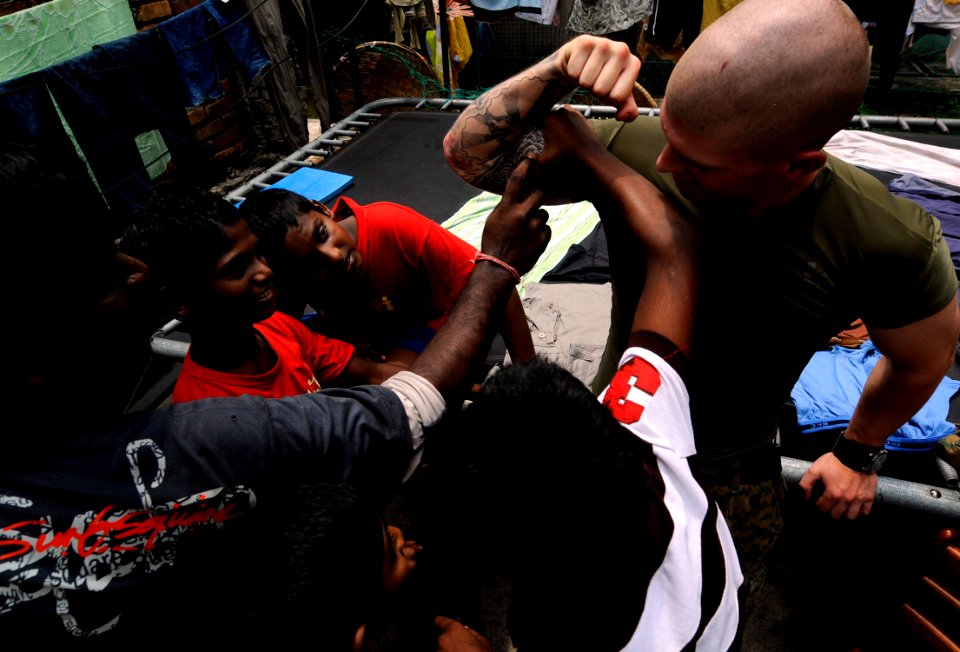 US Navy 091027-N-7280V-792 Cpl. Rick Weaver, assigned to Fleet Anti-terrorism Security Team Pacific (FASTPAC) Company, 5th Platoon, plays with children at Agathians Children's Home during a community service project