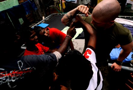 US Navy 091027-N-7280V-792 Cpl. Rick Weaver, assigned to Fleet Anti-terrorism Security Team Pacific (FASTPAC) Company, 5th Platoon, plays with children at Agathians Children's Home during a community service project