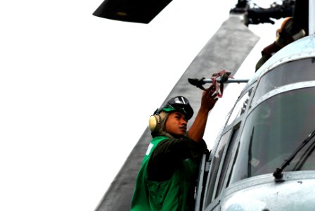 US Navy 091028-N-0807W-160 A Marine assigned to Marine Medium Helicopter Squadron (HMM) 265 conducts a post-flight check on a CH-46 Sea Knight helicopter aboard the amphibious dock landing ship USS Harpers Ferry (LSD 49) photo