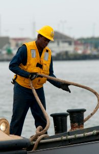 US Navy 091027-N-3592S-022 Boatswain's Mate Seaman Franz Gayle, assigned to Landing Craft Utility (LCU) 1645, throws a mooring line around a bit to secure his boat at Camp Lejeune, N.C
