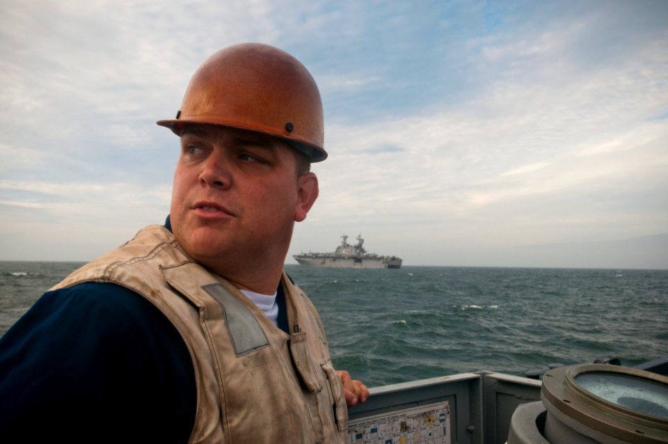 US Navy 091028-N-5319A-229 Engineman 1st Class Johnnie Lowery, assigned to Landing Craft Unit (LCU 1645), watches Marines from the 24th Marine Expeditionary Unit (24th MEU) while en route to the amphibious assault ship USS Nass