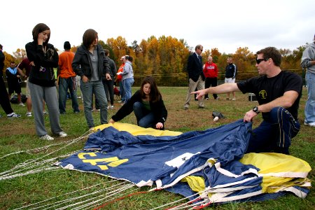 US Navy 091029-N-5366K-012 Chief Special Warfare Operator (SEAL) Justin Gauny, assigned to the U.S. Navy Parachute Team, the Leap Frogs, shows students how to pack his parachute after the team gave a demonstration at South Rive photo