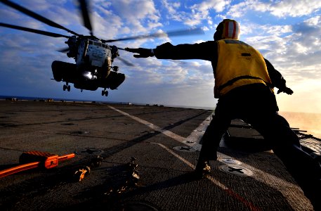 US Navy 091029-N-0807W-629 Boatswain's Mate 3rd Class Solomon Michel, directs a Marine Corps CH-53E Sea Stallion helicopter as it approaches the flight deck of USS Harpers Ferry (LSD 49)