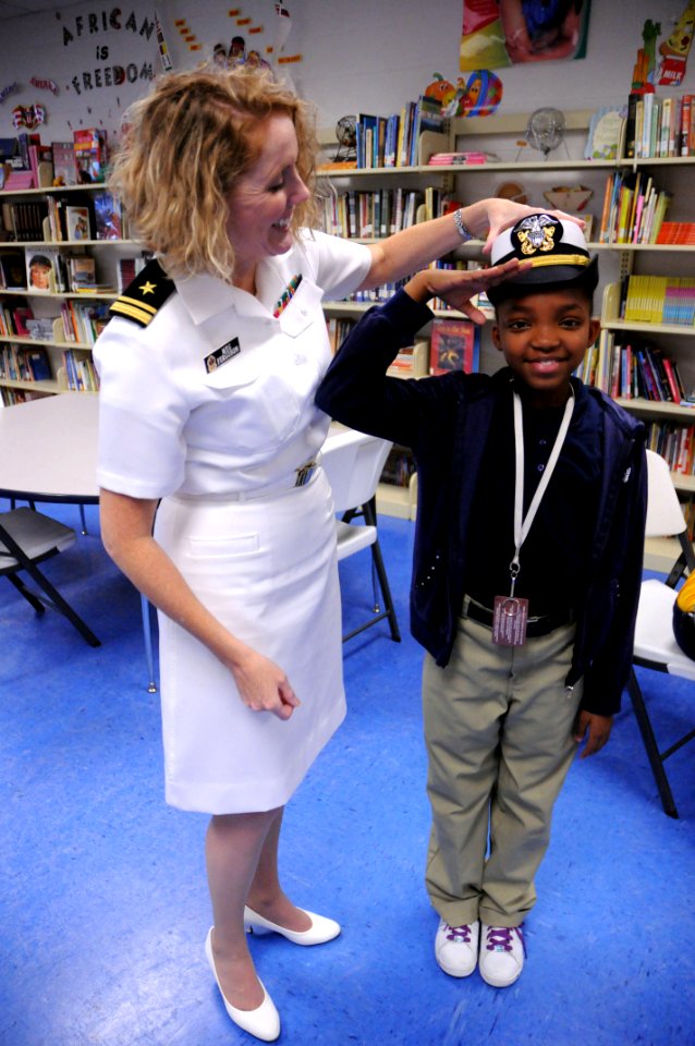 US Navy 091029-N-6220J-006 Lt. j.g. Meg Ferguson teaches a young girl the proper way to salute during a U.S. Navy community service event at the Finnigan Park Boys and Girls Club