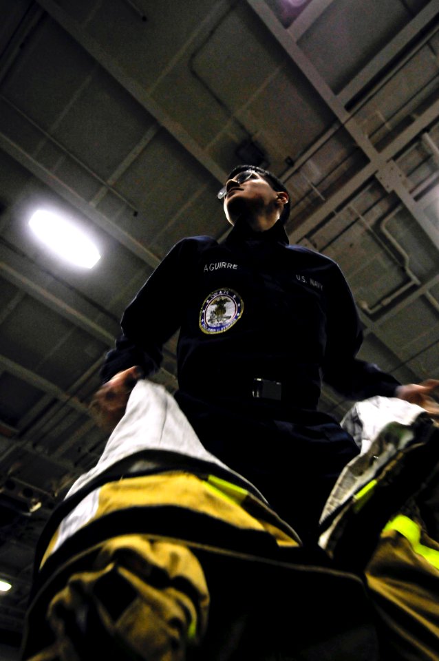 US Navy 091103-N-3541A-007 Mass Communication Specialist Seaman Timothy Aguirre dons a fire-fighting ensemble