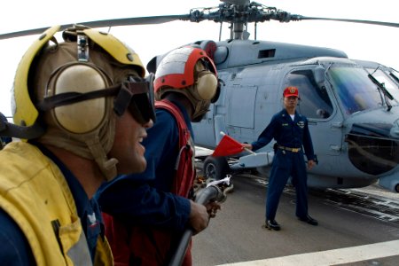 US Navy 091028-N-9123L-013 Boatswain's Mate 3rd Class Eddis Ramirez, from New York, calls instructions as Senior Chief Machinery Repairman Zoilo De Arce waves a flag indicating a class Bravo fire during a crash and smash traini