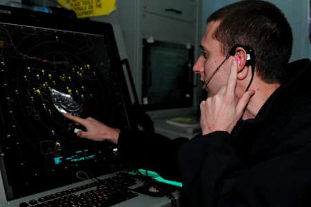 US Navy 091101-N-8960W-009 Air Traffic Controller 3rd Class Elliott Young, assigned to the aircraft carrier USS Nimitz (CVN 68), performs a traffic call to departing aircraft
