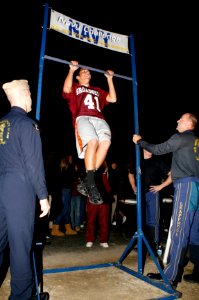 US Navy 091030-N-5366K-155 A student does pull ups as Cmdr. Robert Kaminski and Jim Woods, assigned to the U.S. Navy Parachute Team, the Leap Frogs, keep count photo