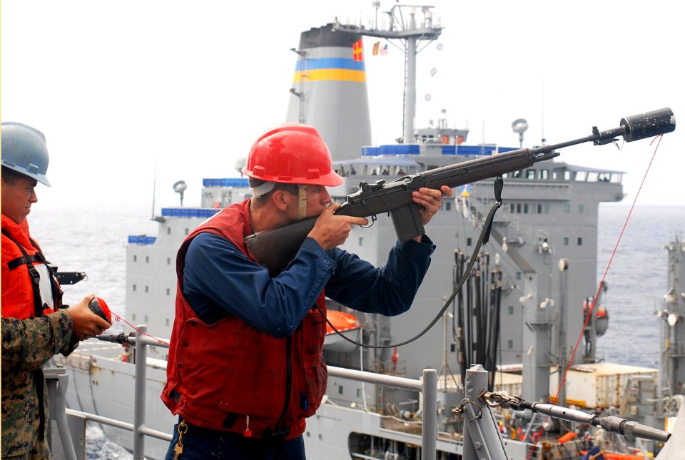 US Navy 091029-N-6692A-038 Gunner's Mate Seaman Thomas Chapman prepares to fire a shot line across to the Military Sealift Command fleet replenishment oiler USNS John Ericsson (T-AO 194)