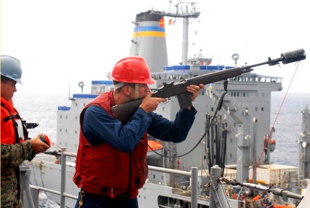 US Navy 091029-N-6692A-038 Gunner's Mate Seaman Thomas Chapman prepares to fire a shot line across to the Military Sealift Command fleet replenishment oiler USNS John Ericsson (T-AO 194)