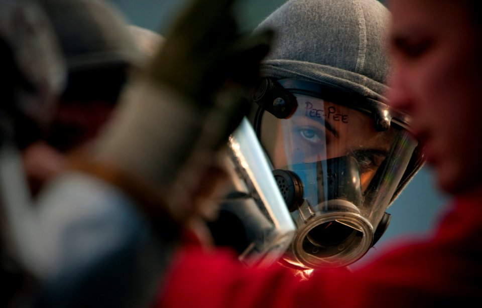 US Navy 091029-N-5319A-049 Aviation Boatswain's Mate (Handling) 3rd Class Olimpo Hurtabo waits to have his firefighting ensemble inspected on the flight deck of the amphibious assault ship USS Nassau (LHA 4)