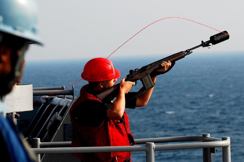 US Navy 091030-N-0807W-107 Gunner's Mate 3rd Class Joshua A. Spooner prepares to fire a shot line to the Military Sealift Command fleet replenishment oiler USNS John Ericsson (T-AO 194)