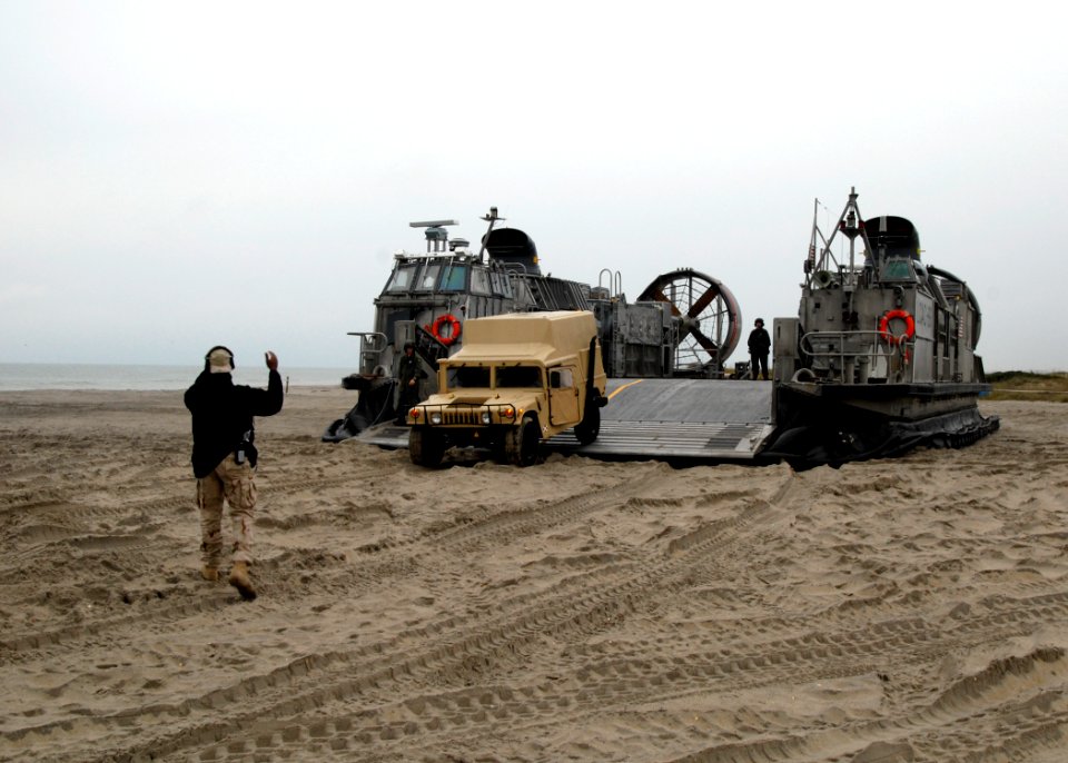 US Navy 091030-N-0924R-011 Seaman Johnny Lloyd, a ramp marshal with Beach Master Unit (BMU) 2, guides a communication vehicle onto Onslow Beach at Camp Lejeune, N.C