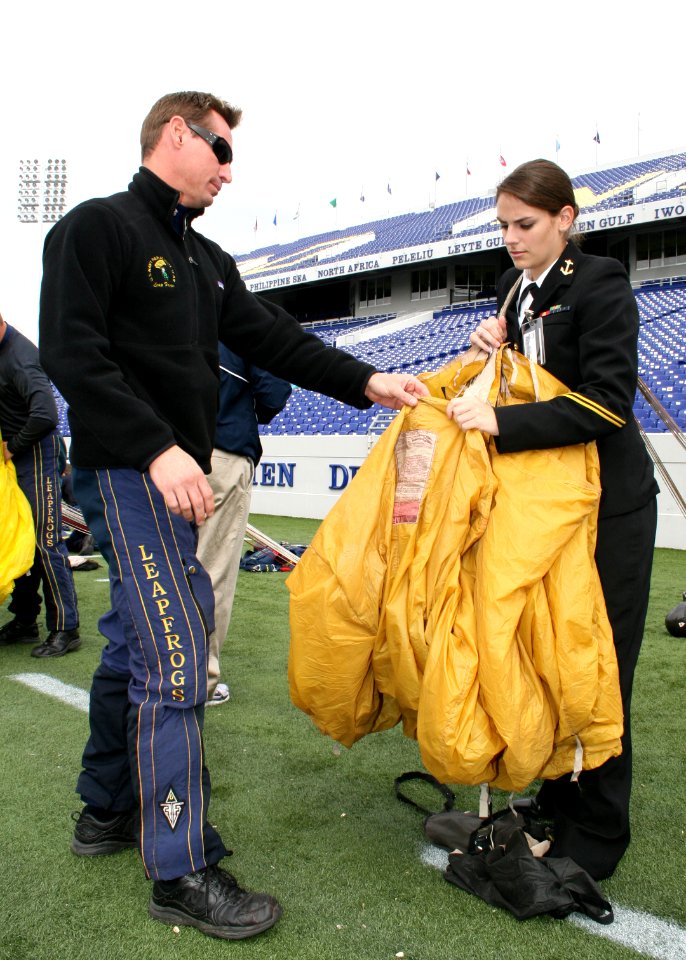 US Navy 091030-N-5366K-021 Chief Special Warfare Boat Operator (SWCC) J.C. Ledbetter, assigned to the U.S. Navy Parachute Team, the Leap Frogs, shows a midshipman from the U.S. Naval Academy's parachute team how to pack