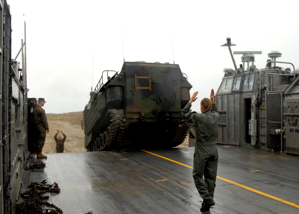 US Navy 091030-N-0924R-069 Boatswain's Mate 3rd Class Angela Brummitt guides a Marine Corps amphibious assault vehicle onto a landing craft, air cushion