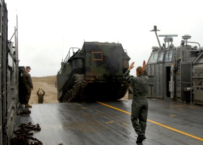US Navy 091030-N-0924R-069 Boatswain's Mate 3rd Class Angela Brummitt guides a Marine Corps amphibious assault vehicle onto a landing craft, air cushion