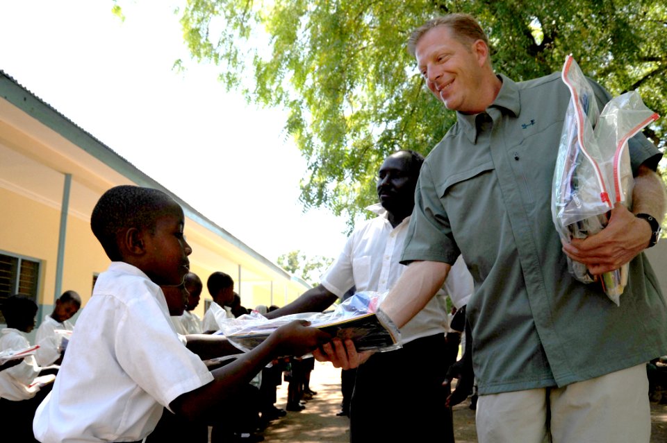 US Navy 091102-N-2420K-101 Boatswain's Mate 1st Class Brian Shapley, from Canadensis, Pa. deployed with Maritime Civil Affairs Team (MCAT) 214, hands a packet of school supplies to a child at the Tongoni Primary School in Tanga