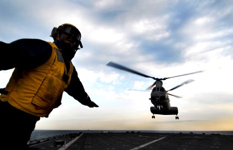 US Navy 091105-N-0807W-371 Boatswain's Mate 3rd Class Solomon Michel signals a Marine Corps CH-46 Sea Knight helicopter to launch photo
