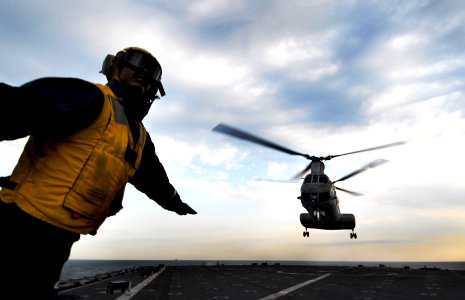 US Navy 091105-N-0807W-371 Boatswain's Mate 3rd Class Solomon Michel signals a Marine Corps CH-46 Sea Knight helicopter to launch