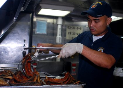 US Navy 091104-N-6692A-077 Culinary Specialist Seaman Alvic Dedios prepares dinner aboard the amphibious dock landing ship USS Tortuga (LSD 46)