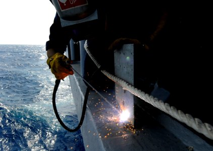 US Navy 091104-N-7280V-773 Hull Technician 3rd Class Alex Bonner replaces an electrical bracket on the starboard sponson aboard the amphibious command ship USS Blue Ridge (LCC 19). Blue Ridge is underway on a scheduled deployme