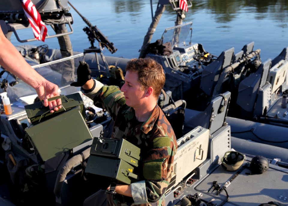 US Navy 091105-N-4205W-002 Special warfare combatant-craft crewmen from SEAL Team 18 inventory ammunition for an 11-meter rigid-hull inflatable boat