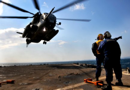 US Navy 091102-N-0807W-303 Boatswain's Mate 3rd Class Solomon Michel signals a Marine Corps CH-53E Sea Stallion helicopter aboard the amphibious dock landing ship USS Harpers Ferry (LSD 49)