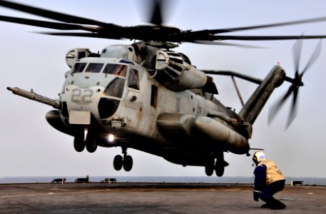 US Navy 091104-N-0807W-394 Senior Chief Boatswain's Mate Marvin Guinto observes a Marine Corps CH-53E Sea Stallion helicopter land aboard the amphibious dock landing ship USS Harpers Ferry (LSD 49) photo