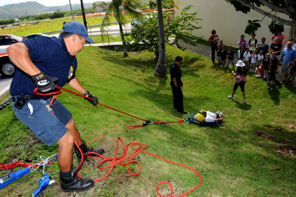 US Navy 091105-N-1906L-003 Firefighter Bill Roberto, assigned to Navy Fire and Emergency Services Station 1, hoists a litter basket to demonstrate to students from Commander William C. McCool Elementary and Middle School