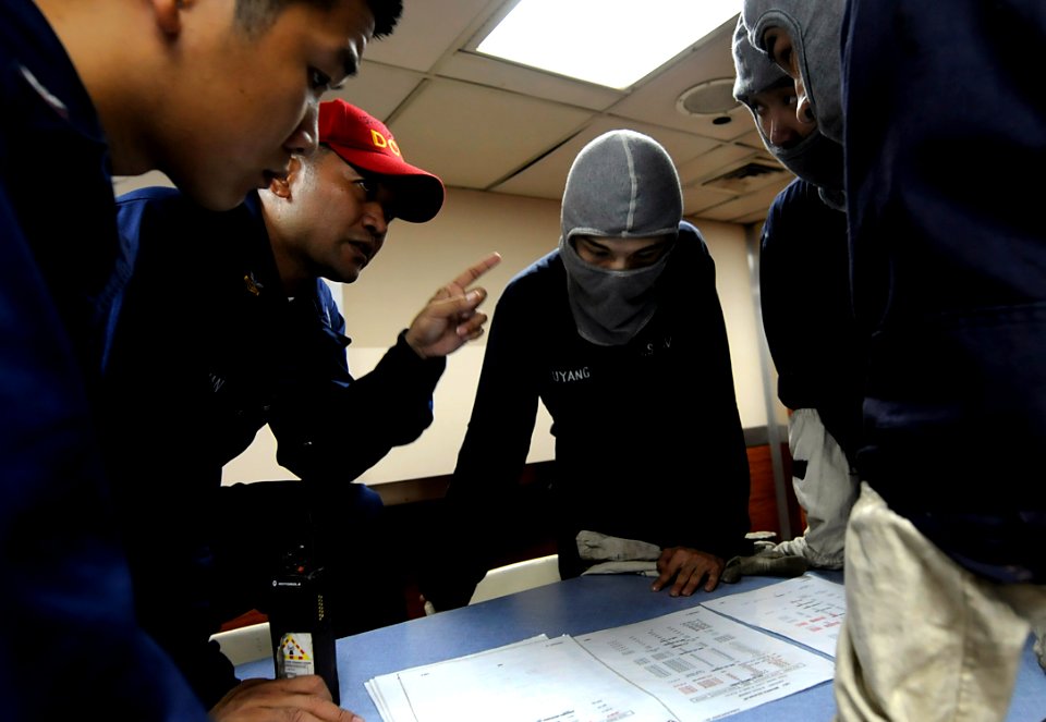 US Navy 091104-N-7280V-448 Machinist's Mate 1st Class Roberto Deguzman, assigned to the damage control training team of the amphibious command ship USS Blue Ridge (LCC 19), instructs members of the Repair 2 mechanical isolation