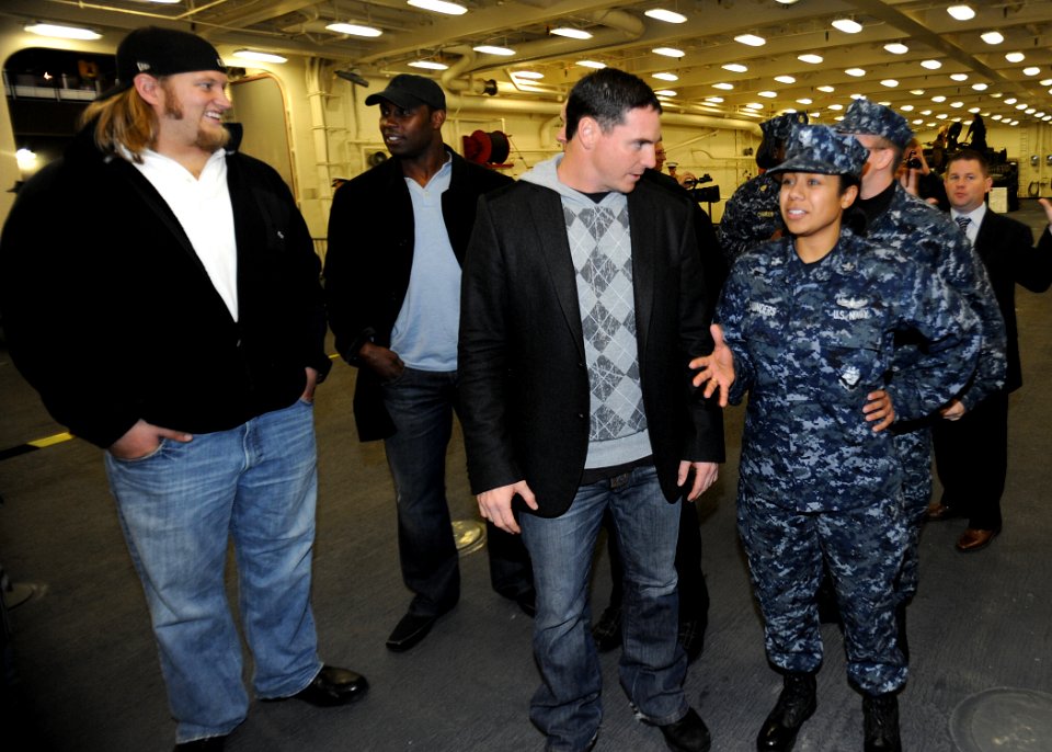 US Navy 091103-N-2147L-004 nformation Systems Technician 2nd class Nicole Saunders explains the characteristics of the amphibious transport dock ship Pre-Commissioning Unit (PCU) New York (LPD 21) to New York Jets football pl