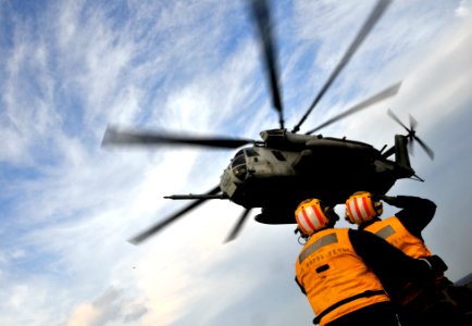 US Navy 091104-N-0807W-407 Aviation Boatswain's Mate (Handling) 1st Class Giancarlo Treano launches a Marine Corps CH-53E Sea Stallion helicopter from the amphibious dock landing ship USS Harpers Ferry (LSD 49)