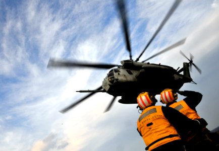 US Navy 091104-N-0807W-407 Aviation Boatswain's Mate (Handling) 1st Class Giancarlo Treano launches a Marine Corps CH-53E Sea Stallion helicopter from the amphibious dock landing ship USS Harpers Ferry (LSD 49) photo