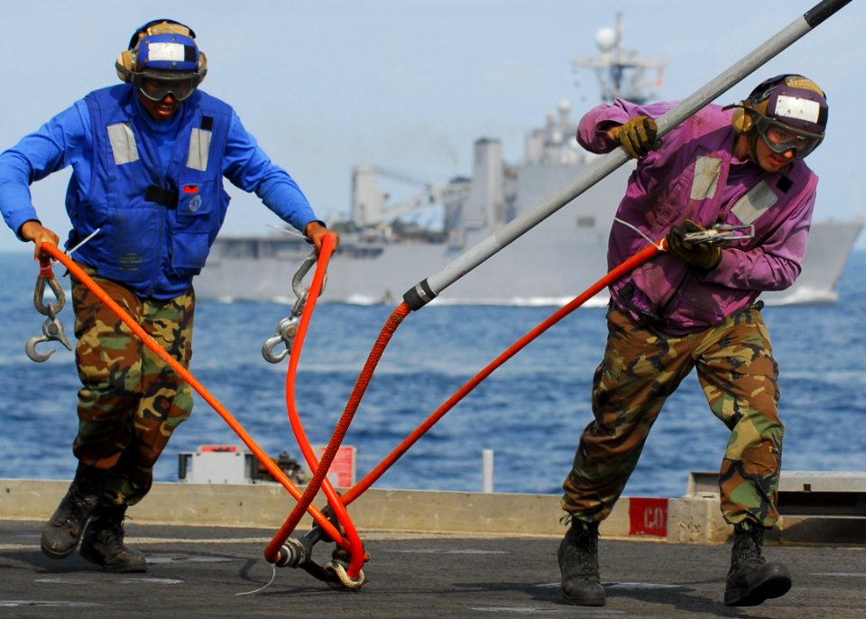 US Navy 091106-N-5538K-040 Sailors assigned to the amphibious transport dock ship USS Denver (LPD 9) remove a cargo pendant from fresh supplies during a vertical replenishment