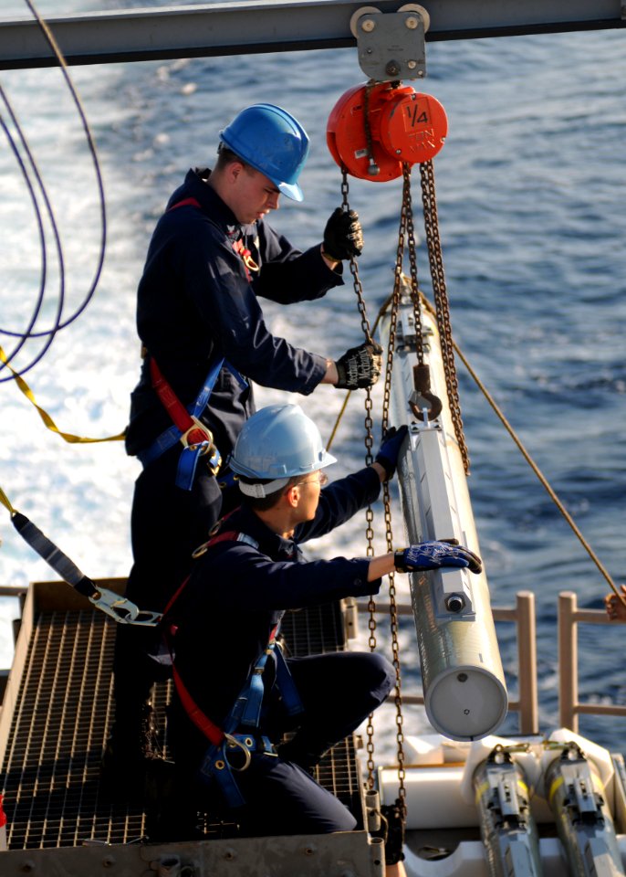 US Navy 091106-N-0120A-070 Fire Controlman 3rd Class Shane Nichlos, left, and Fire Controlman 3rd Class Tan Ngo guide a RIM-116 Rolling Airframe Missile (RAM)