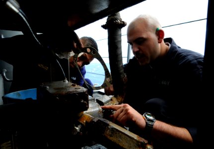US Navy 091104-N-7280V-772 Chief Engineman Manuel Jamosmos, left, and Engineman Fireman Kelly Cunningham replace a gasket on a slewing arm davit pump motor aboard the amphibious command ship USS Blue Ridge (LCC 19) photo