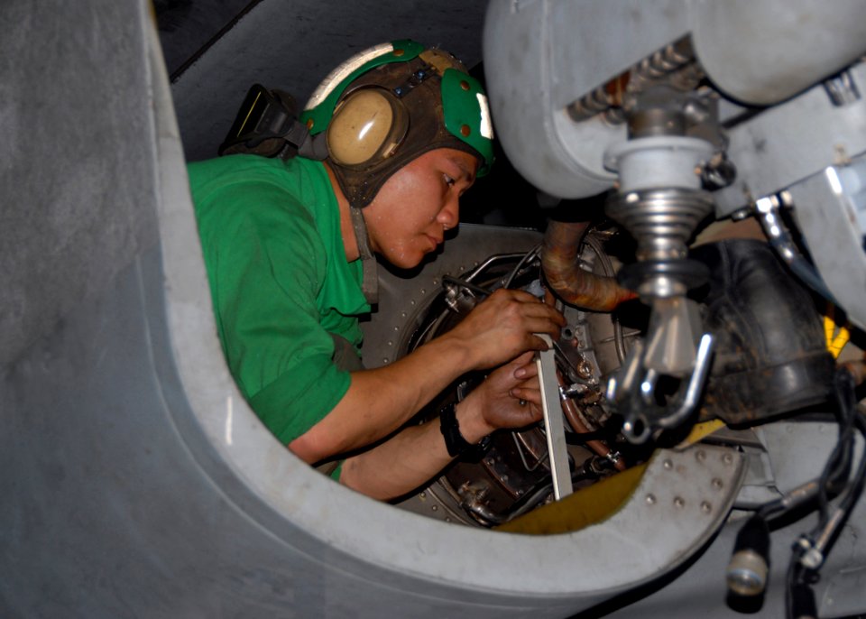 US Navy 091107-N-1644H-245 Aviation Machinist Mate 3rd Class Khanh Ngo, assigned to the Warlords of Helicopter Anti-Submarine Squadron Light (HSL) 51, replaces an T700-401C engine inside an SH-60B Sea Hawk helicopter