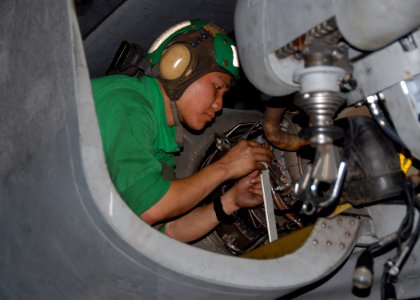 US Navy 091107-N-1644H-245 Aviation Machinist Mate 3rd Class Khanh Ngo, assigned to the Warlords of Helicopter Anti-Submarine Squadron Light (HSL) 51, replaces an T700-401C engine inside an SH-60B Sea Hawk helicopter