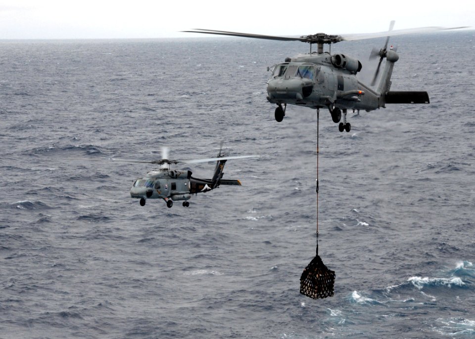 US Navy 091105-N-1644H-184 Two SH-60F Sea Hawk helicopters assigned to the Chargers of Helicopter Anti-Submarine Squadron (HS) 14 transport cargo to the aircraft carrier USS George Washington (CVN 73)
