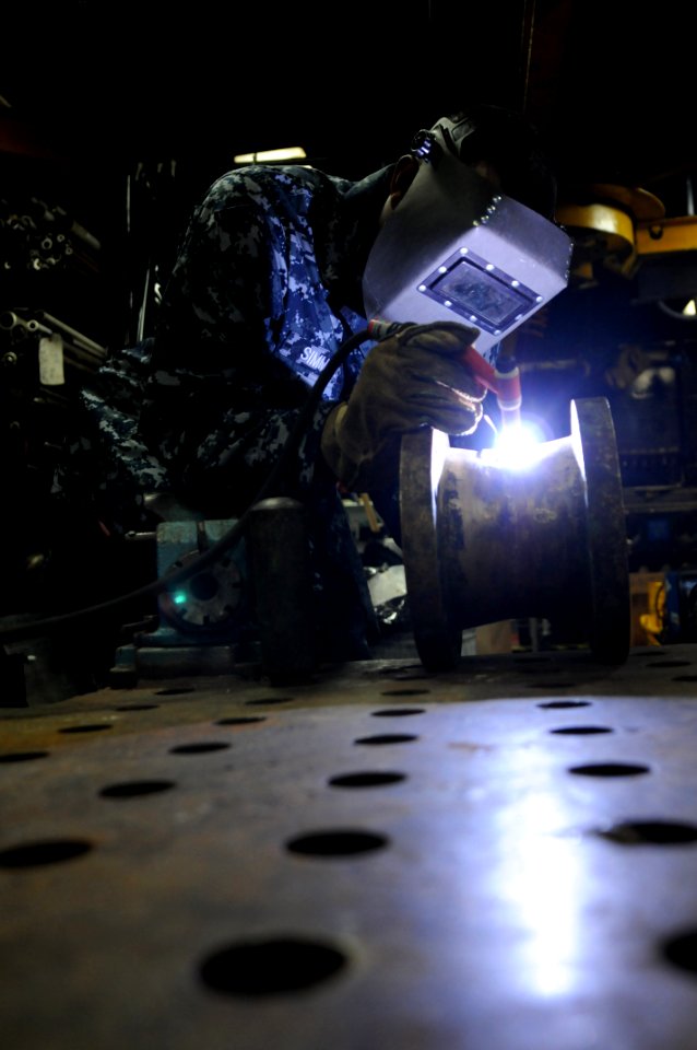 US Navy 091106-N-0890S-316 Hull Maintenance Technician 3rd Class Johnathan Simmons Tig welds the spool of a fire pump aboard the multipurpose amphibious assault ship USS Wasp (LHD 1)