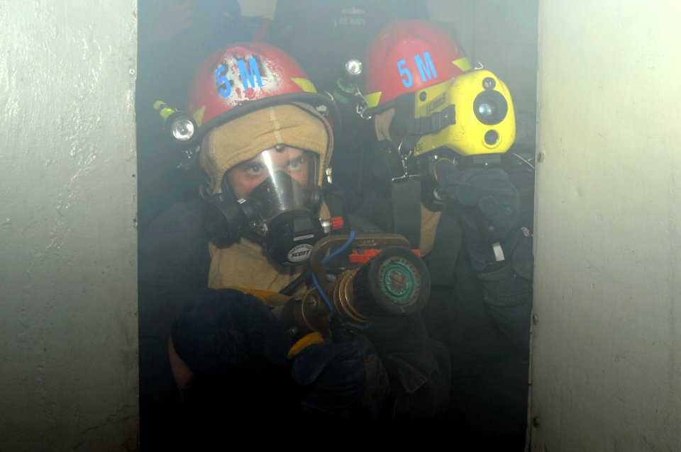 US Navy 091105-N-0890S-013 Sailors fight a mock fire in the waste processing room during a general quarters drill aboard the multipurpose amphibious assault ship USS Wasp (LHD 1)