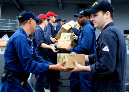 US Navy 091107-N-7478G-551 Sailors assigned to the amphibious command ship USS Blue Ridge (LCC 19) offload boxes of humanitarian supplies donated from Project Handclasp