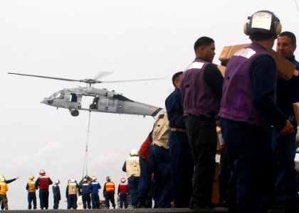 US Navy 091106-N-6692A-098 Sailors and Marines aboard the amphibious dock landing ship USS Tortuga (LSD 46) pass stores during a vertical replenishment with the Military Sealift Command dry cargo-ammunition ship USNS Alan Shepa