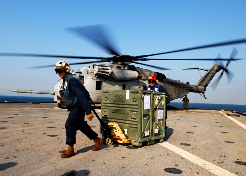 US Navy 091105-N-6692A-065 Lance Cpl. Nick Jackson and Lance Cpl. Ricardo Navarrete unload a box of equipment from a Marine Corps CH-53 Sea Stallion helicopter