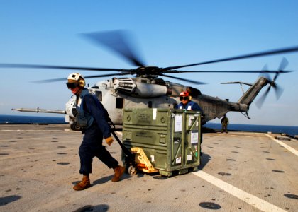 US Navy 091105-N-6692A-065 Lance Cpl. Nick Jackson and Lance Cpl. Ricardo Navarrete unload a box of equipment from a Marine Corps CH-53 Sea Stallion helicopter