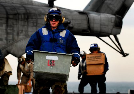 US Navy 091105-N-0807W-191 Seaman Craig R. Murphy carries supplies and equipment from a Marine Corps CH-53E Sea Stallion helicopter