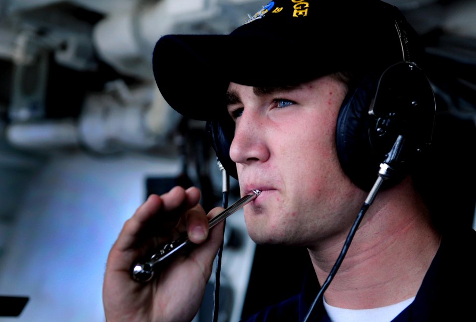 US Navy 091105-N-7478G-074 Boatswain's Mate Seaman Christopher Pridmore practices on the boatswain's pipe while standing aft lookout watch