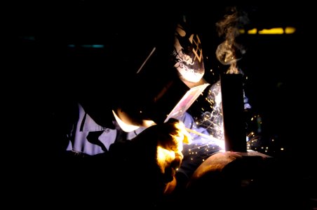 US Navy 091105-N-7478G-054 Hull Maintenance Technician Fireman Cole French welds a T-shaped bracket for a bulkhead